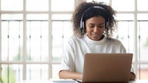 woman sitting on laptop with headphones