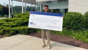 Dominic holding a check