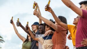 people cheering while holding beers