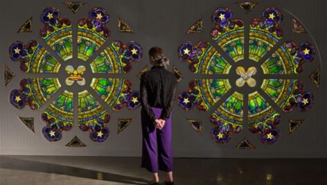 person standing in front of the colorful tiffany windows