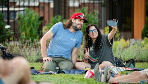 couple sitting on blanket outside taking a selfie