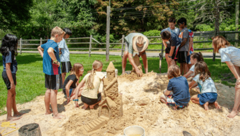 Chuck Feld teaching kids at Hands on History Camp how to make a professional sand castle.