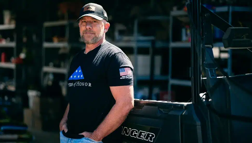 Col. Nick Nichols standing by a truck on his farm.