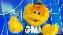 Good morning america's mascot ray of sunshine, a yellow fluffy monster wearing GMA t-shirt