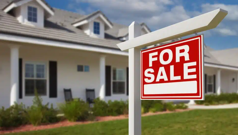 For Sale Real Estate Sign in Front of New House.