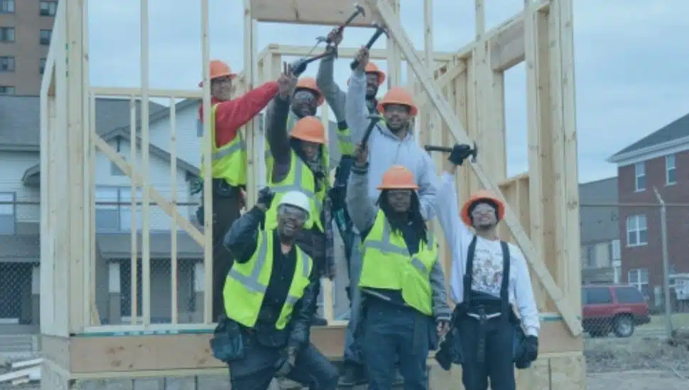 people holding hammers in front of wooden beams