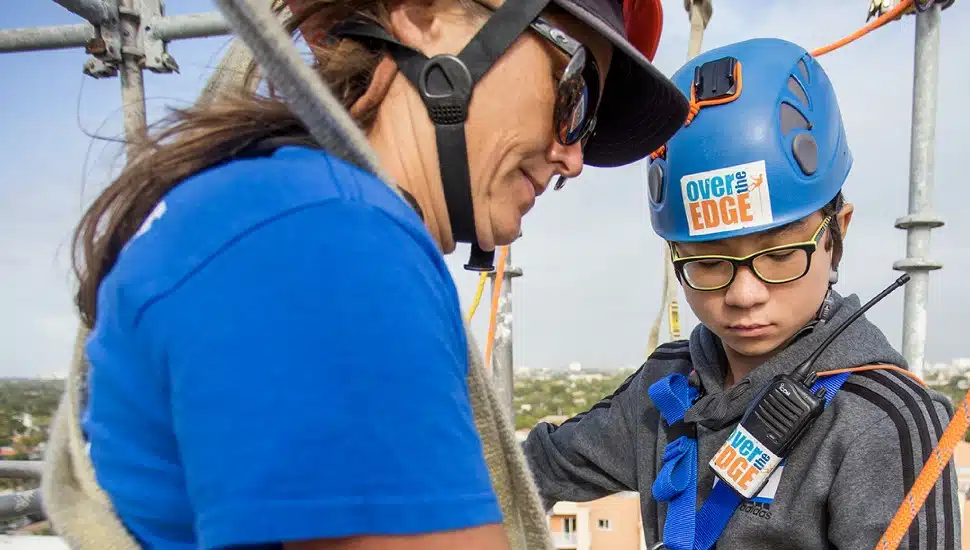 two people rappelling on ropes for a fundraiser