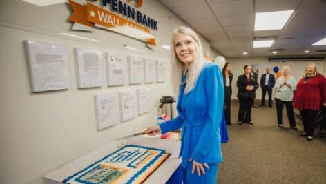 Director of Human Resources Roberta Hoffman cutting cake at Mid Penn Bank