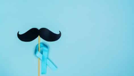 Movember background. Blue ribbon and black fake paper moustaches.