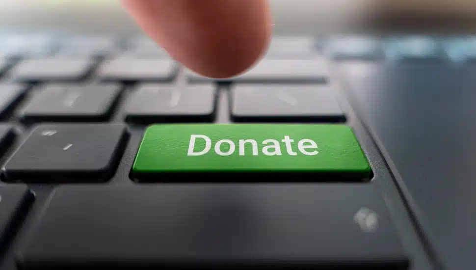 person press green donate button on computer