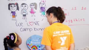 A YMCA camp counselor and child spend time together at Camp Bumblebee