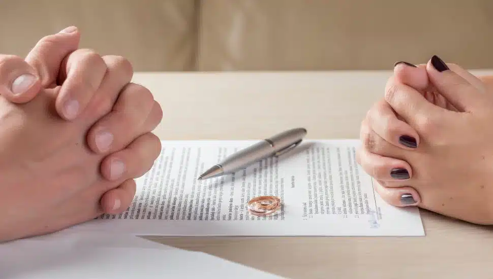 hands of wife and husband signing prenup