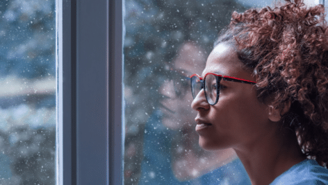 woman with seasonal affective disorder staring out a window