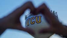 person making a heart symbol with their hands around WCU
