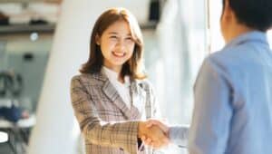 student shaking hands with potential employer.