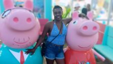 Yuana S. enjoys a lighter moment with two pig mascots.
