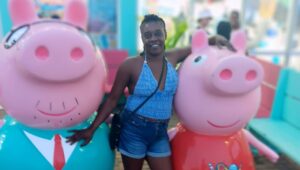 Yuana S. enjoys a lighter moment with two pig mascots.