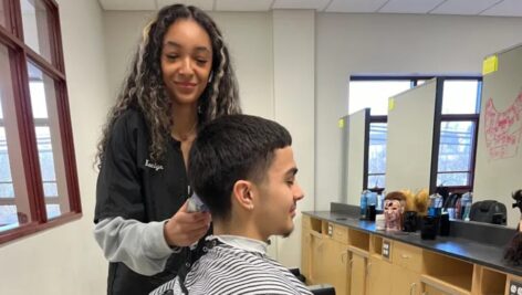 student cutting another's hair in barbering class