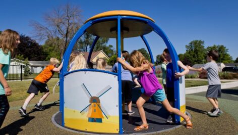 Children playing on a playground spinner. P