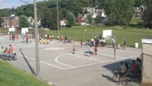 people and kids playing basketball at ash park