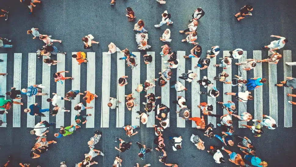 lots of people walking across a crosswalk