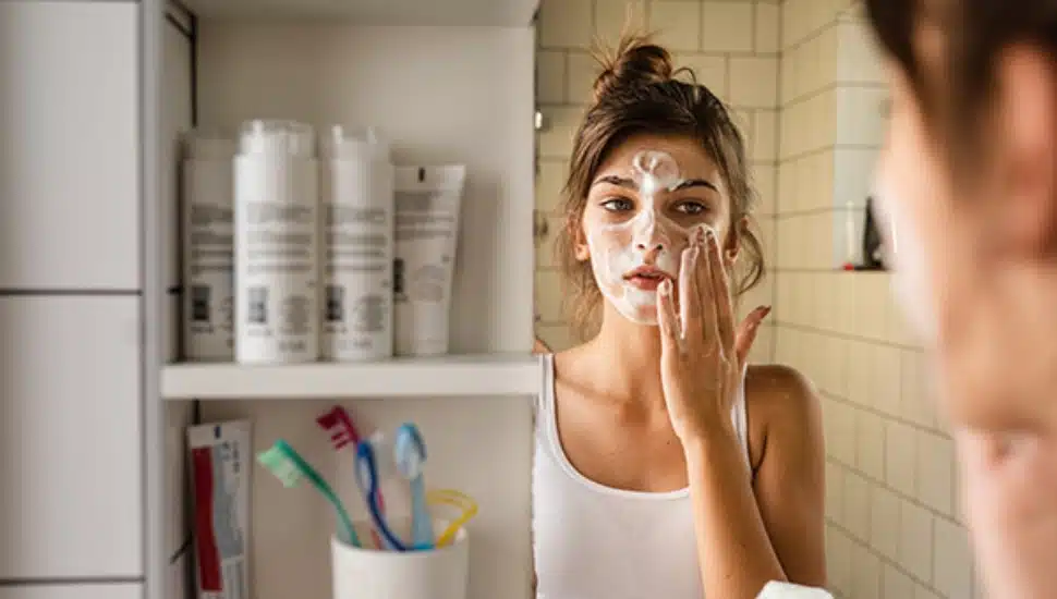 Young woman having daily washing and cleaning skin routine in the bathroom