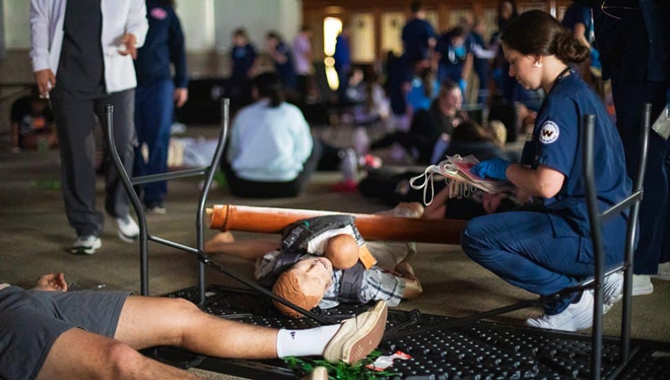 A nursing student works in the dark in Latham Hall on campus providing triage and first aid during the Widener disaster drill that simulated a tornado hitting the campus