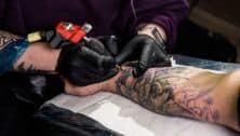 tattoo artist tattooing someone's arm