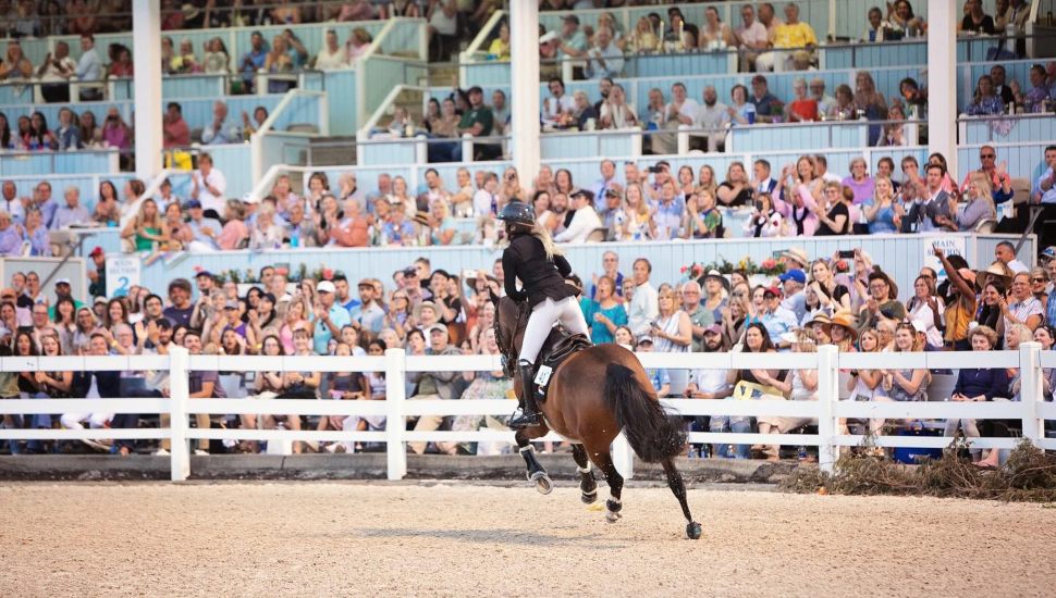 girl riding horse in front of huge crowd