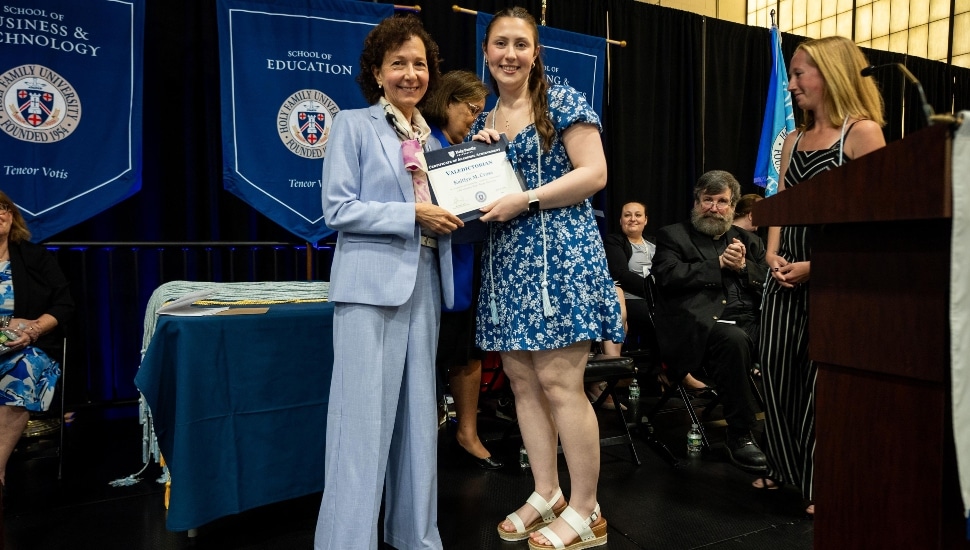 Kaitlyn Cross, HFU's Class of 2024 Valedictorian, on stage at Holy Family University's graduation ceremony.