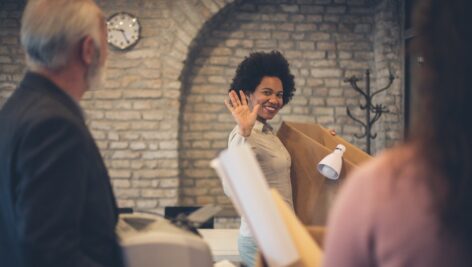 Woman carrying her belongings out of the office after quitting with class