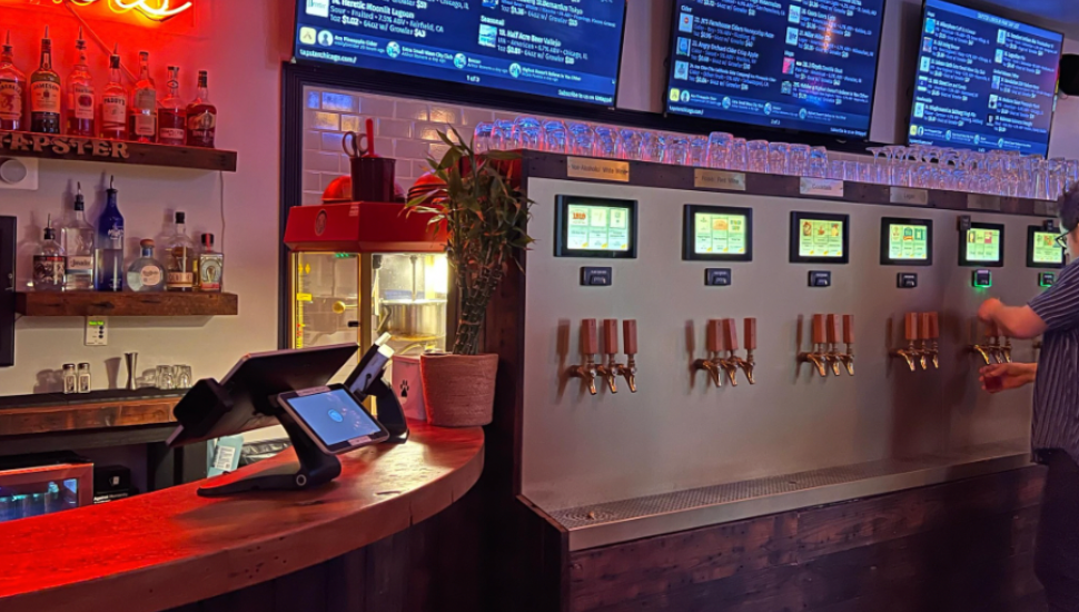 person pouring drink from beer wall