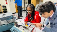 Electrical Engineering Professor Ali Hamza works with a student in the lab.