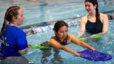 An instructor teaching water-safety skills in the pool.