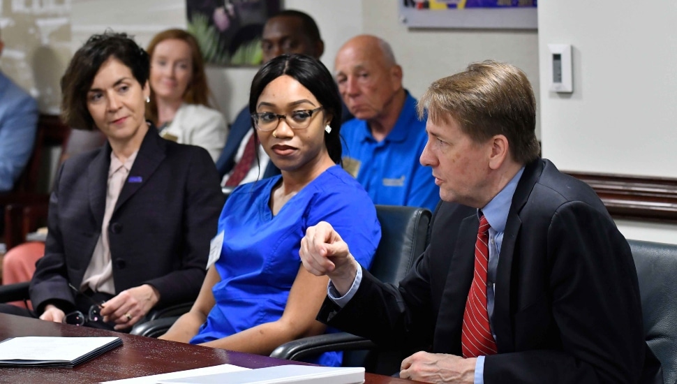 (L to R) DCCC President Marta Yera Cronin, Ed.D. and a Nurse Aide Program student Mona Coulibaly look on as Federal Student Aid chief operating officer Richard Cordray discusses financial aid for workforce training programs.