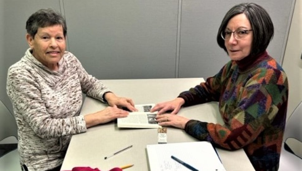 Image of a tutor with a student sitting at a table learning, as part of the CCOIC Adult Tutoring Program.