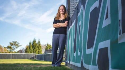 Katie Warrington Hugelmeyer standing on the WilmU softball field.