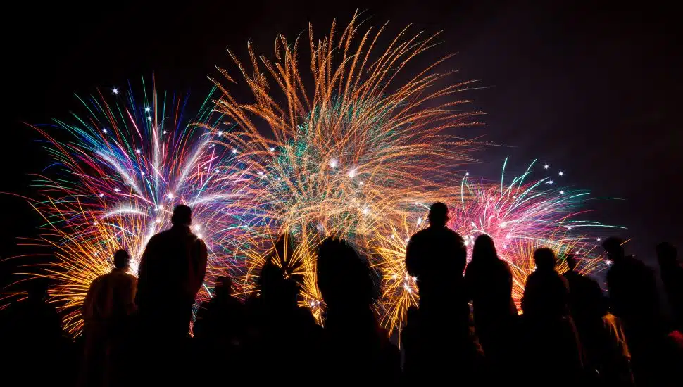 Big fireworks with silhouettes of people watching it