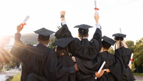 students in cap and gowns celebrating graduation