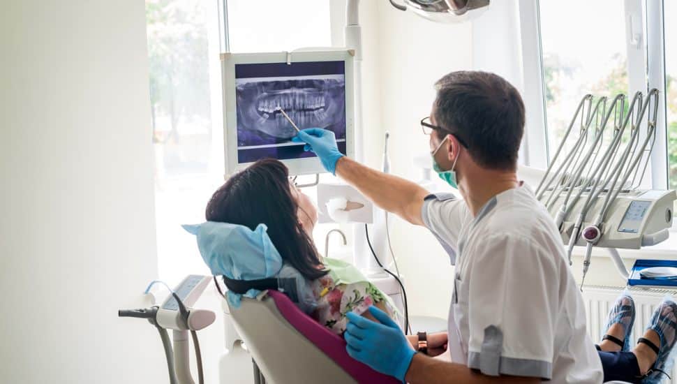 dentist showing patient's teeth on X-ray