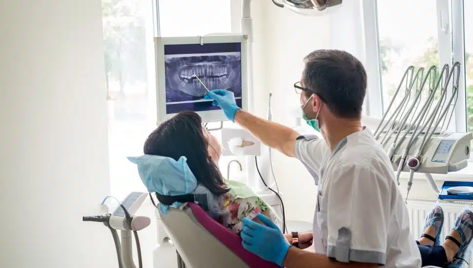 dentist showing patient's teeth on X-ray