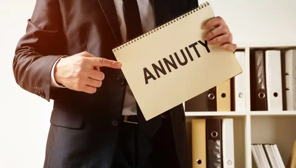 A man in a suit holding a paper with the word "annuity."