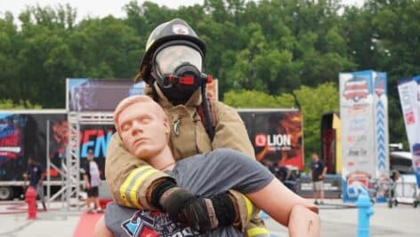 A firefighter locks in and drags Rescue Randy's 175-pound body to the finish line