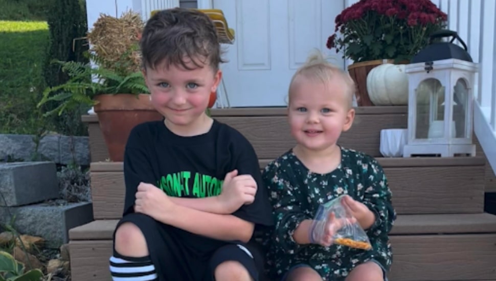 Two young children sitting on their porch.