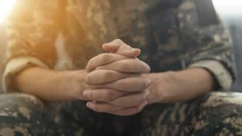 veteran holding hands resting on legs