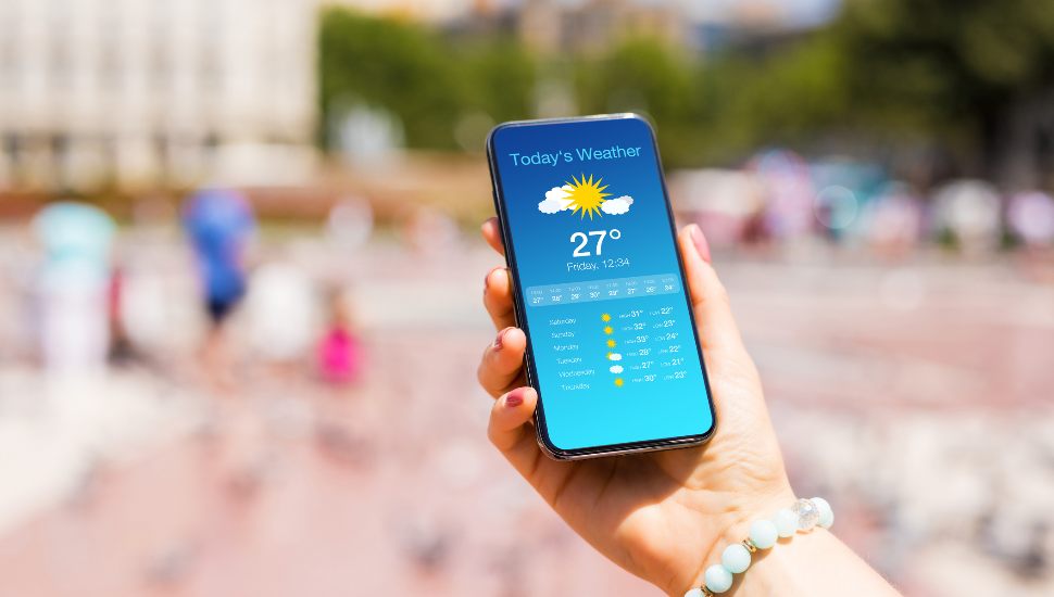 woman looking at weather forecast app