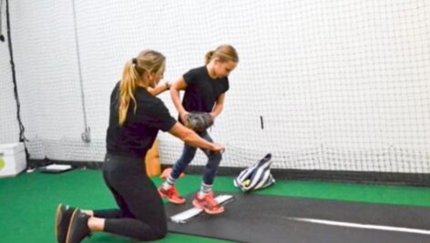 PIC Julie Sebastian gives instructions to a young girl softball player.