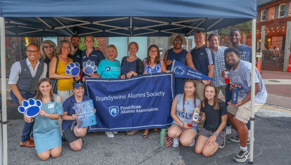 Members of the Penn State Brandywine Alumni Association gather under the tent at a past Media Borough 'Dining Under the Stars' event.