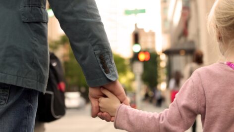 person holding hands with small child