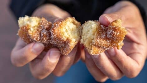 man holding apple cider donuts